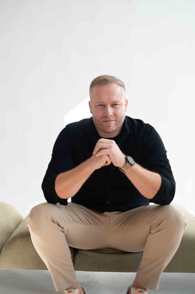 Györe Norbert ingatlanügyintéző fekete ingben