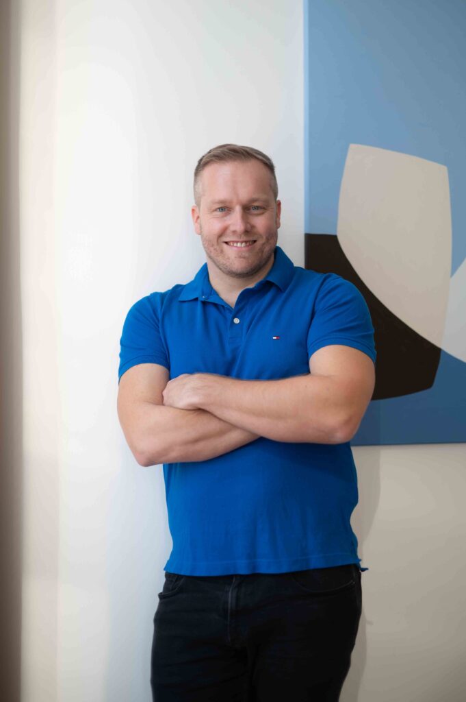 Györe Norbert ingatlanügyintéző kék pólóban